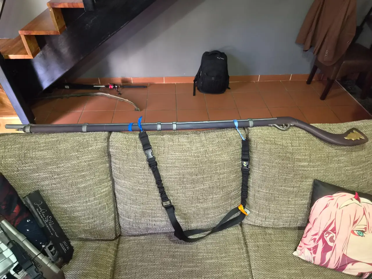 Rip Van Winkle's long flintlock musket resting across the back of a couch, with metal barrel bands, a curved stock and a brass-coloured stock plate