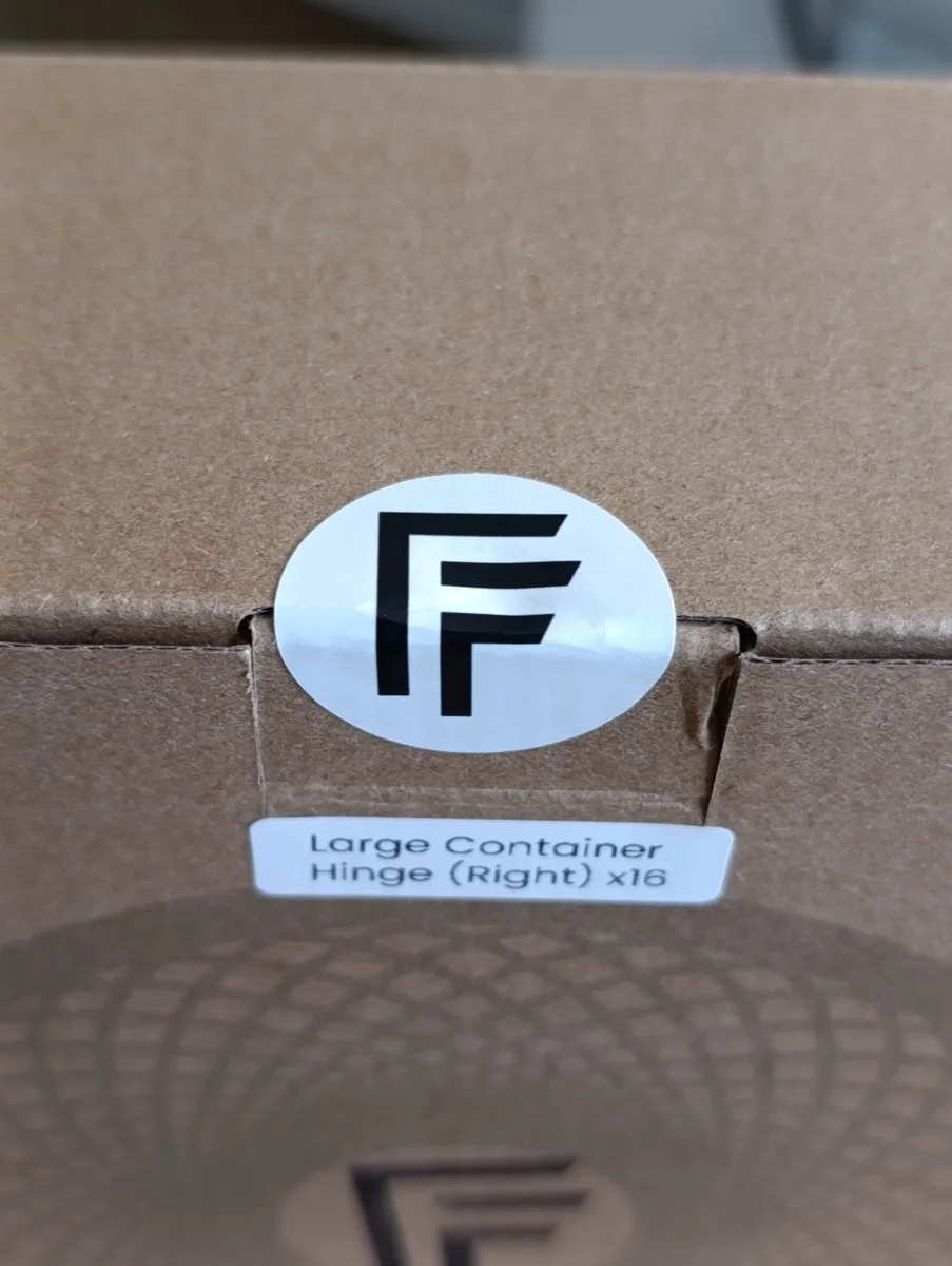 Close-up of the F&F logo sticker on the sealed box flap