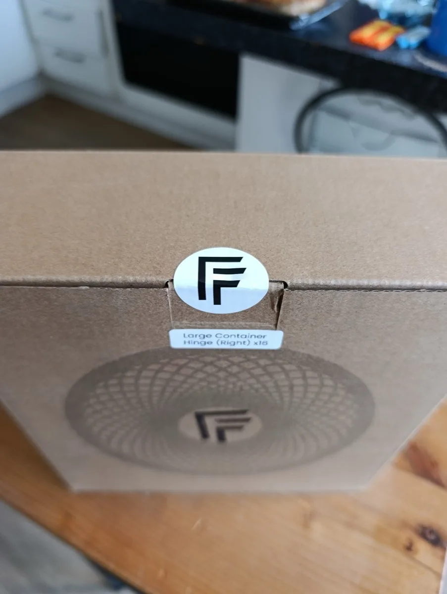 Side view showing the logo sticker sealing the flap and the contents label below