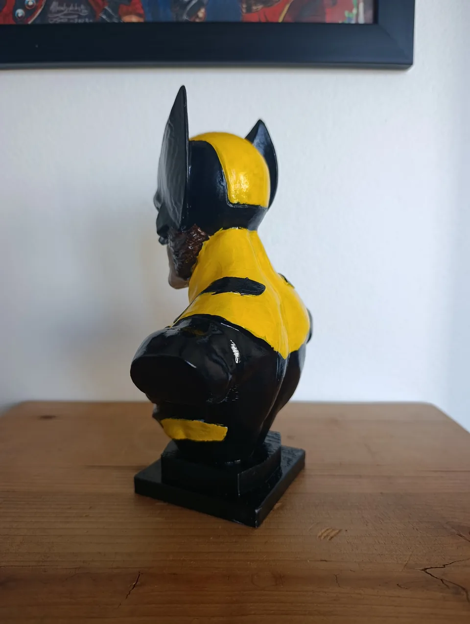 The Wolverine bust from behind at an angle, showing the painted suit pattern across the back and one cowl fin