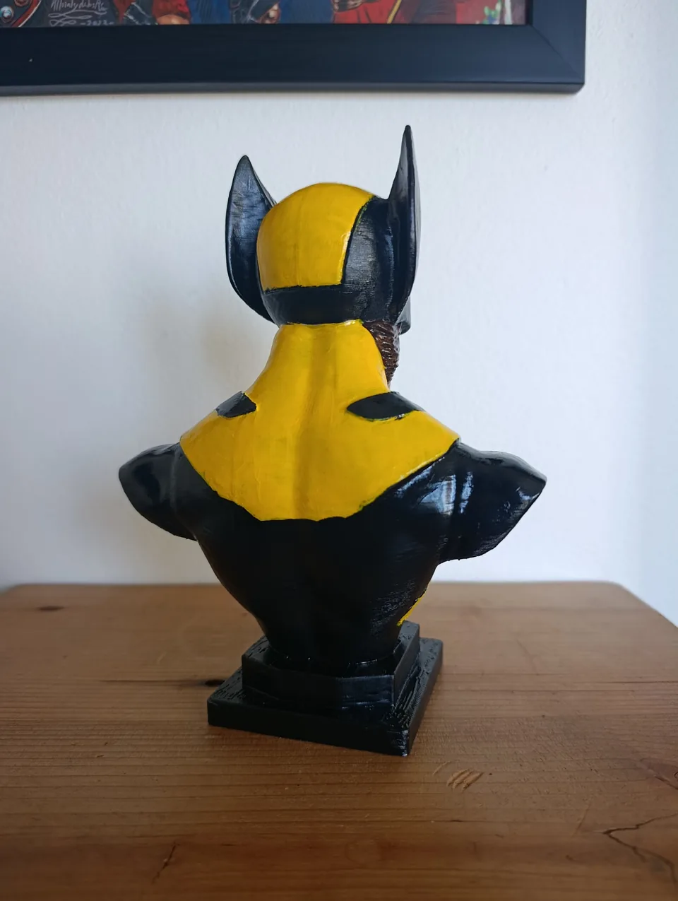 The back of the Wolverine bust, with the yellow and black suit pattern continuing across the shoulders and the back of the cowl