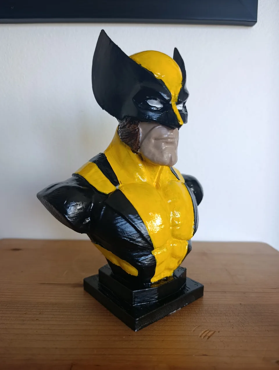 The Wolverine bust from a three-quarter angle, showing the black panels wrapping from the shoulders down the chest
